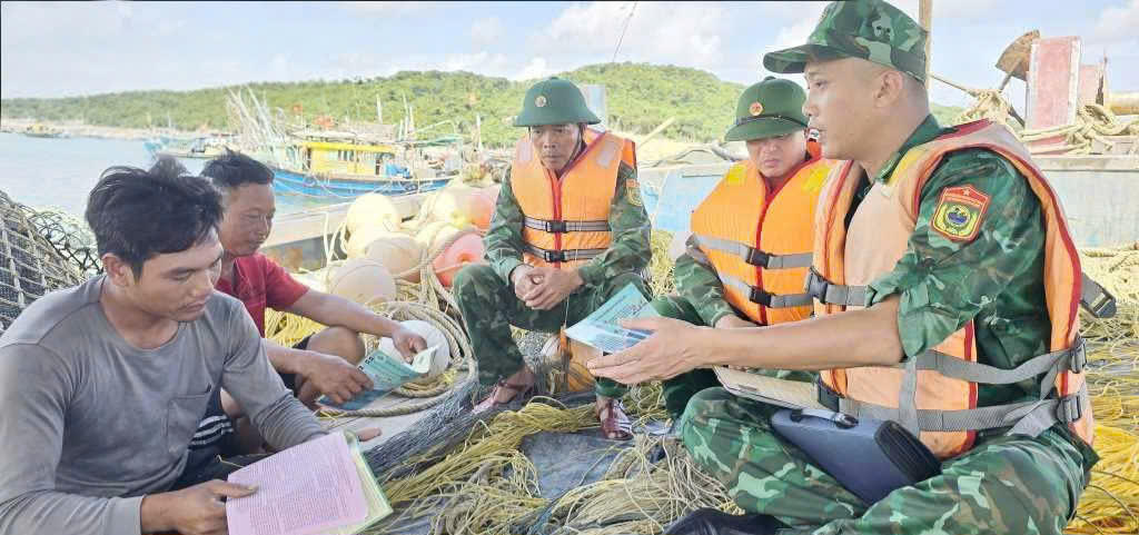 Cán bộ Đồn biên phòng Cô Tô xuống tận tàu cá để tuyên truyền, phổ biến cho ngư dân. Ảnh: QMG.