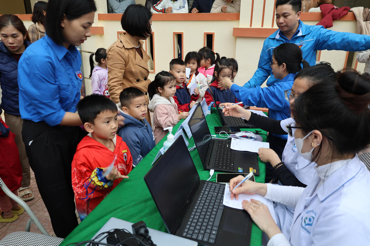 Các y, bác sĩ ghi thông tin học sinh trước khi thăm khám.