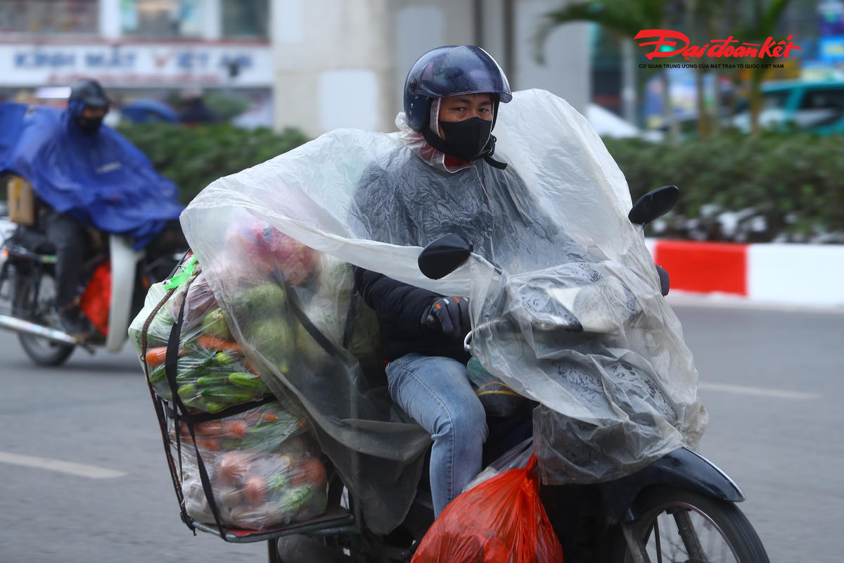 Để chống chọi với cái rét buốt, nhiều người lao động phải khoác thêm áo mưa bên ngoài lớp áo ấm nhằm ngăn gió lạnh và giữ nhiệt cơ thể.
