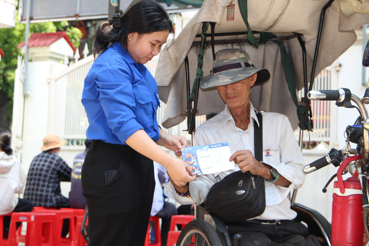 Trao vé cho một người khuyết tật làm nghề bán vé số tại TP Hồ Chí Minh về quê TP Đà Nẵng. Ảnh: Q.Đ.