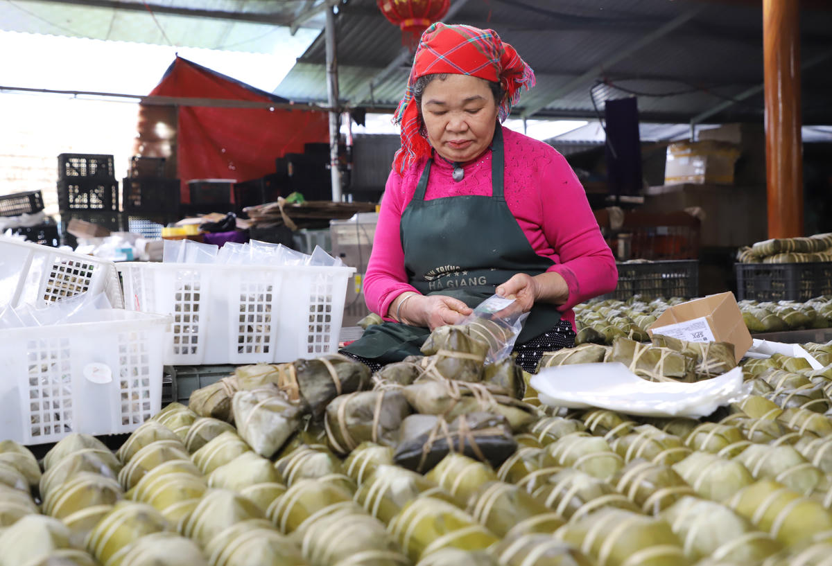 Bà Dung, Giám đốc HTX bánh chưng gù bà Dung chia sẻ về bí quyết gói bánh chưng gù. Ảnh: N.Q