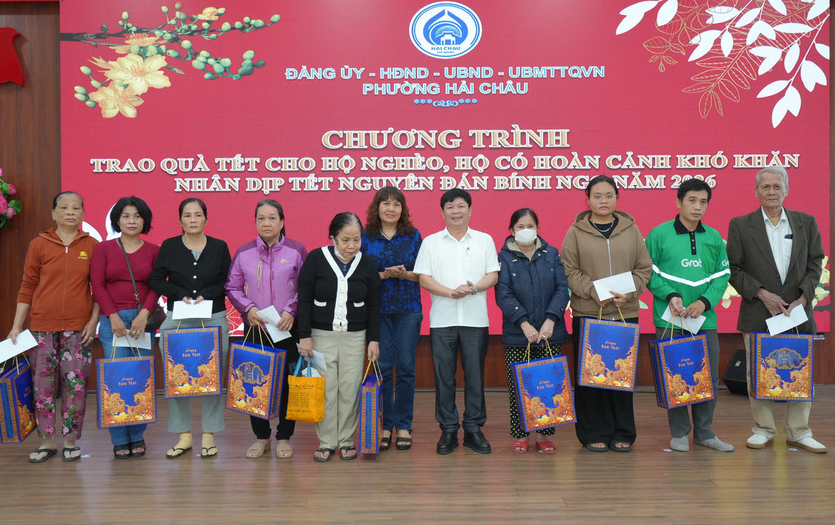 Ông Nguyễn Văn Duy, Chủ tịch UBND phường Hải Châu (giữa) trao quà cho người dân. Ảnh: Nguyễn Tú.