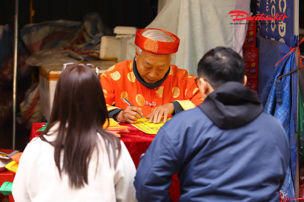 Các quầy viết sớ phía ngoài cổng phủ tấp nập người dân ra vào, hoạt động liên tục suốt buổi trưa.