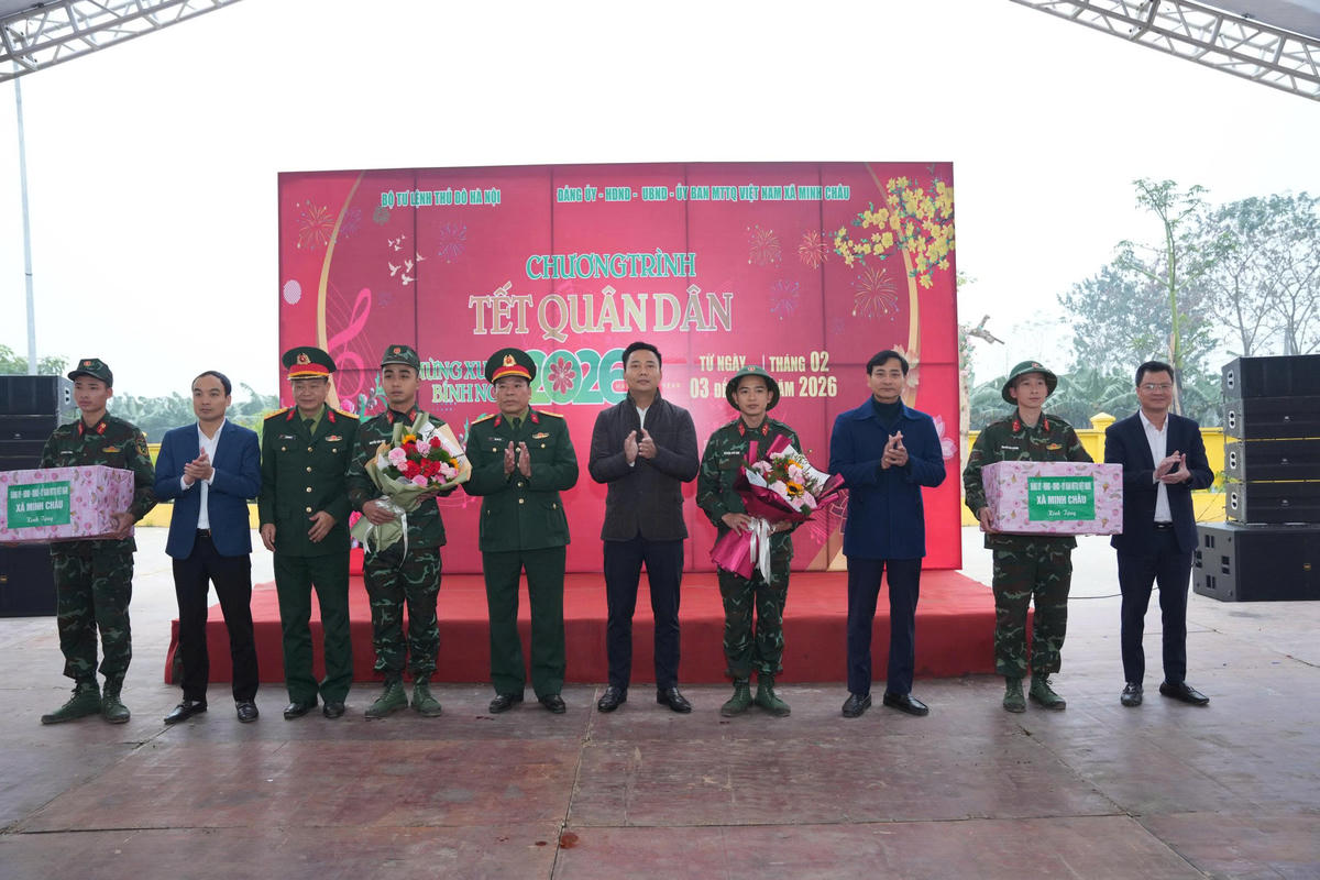 Bí thư Đảng ủy, Chủ tịch HĐND xã Minh Châu Nguyễn Đức Tiến tặng hoa cho các chiến sĩ quân đội.