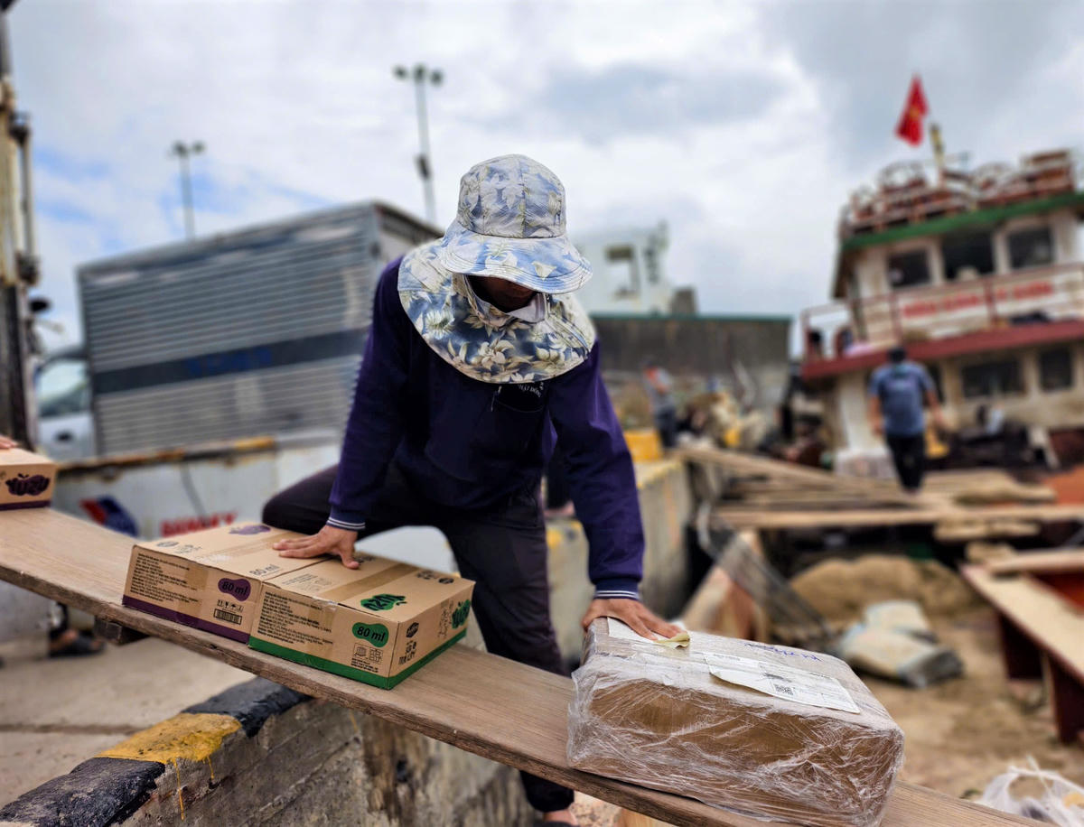 Nhân công bốc xếp hàng hóa lên tàu vận tải. CV.