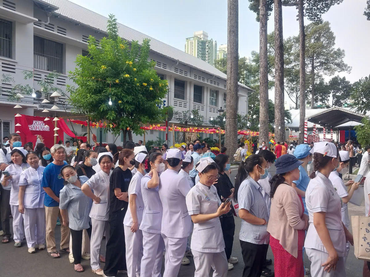 Cán bộ, nhân viên bệnh viện cùng người bệnh, thân nhân bệnh viên xếp hàng dài xin chữ thư pháp mong một năm sức khỏe, bình an, hạnh phúc. Ảnh: S.X