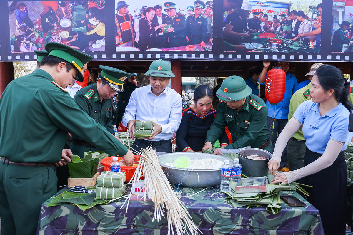 Tổng Biên tập Báo Đại đoàn kết Trương Thành Trung và lãnh đạo Bộ đội Biên phòng tỉnh Đắk Lắk gói bánh chưng cùng bà con nhân dân xã Buôn Đôn. Ảnh: Quanh Vinh.