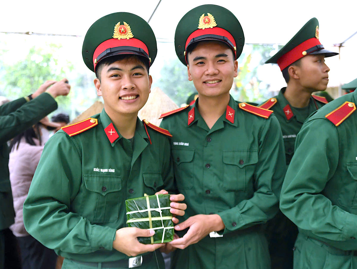 Các chiến sĩ Trường Sĩ quan Lục quân 1 – Đại học Trần Quốc Tuấn hào hứng, phấn khởi khi trực tiếp gói những chiếc bánh chưng nghĩa tình, gửi trao tới các gia đình có hoàn cảnh khó khăn, lan tỏa tinh thần sẻ chia trong những ngày giáp Tết. Ảnh: Phạm Sỹ.