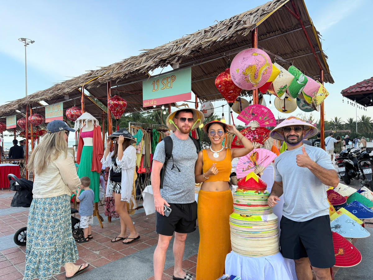 Du khách mua nón lá tại chương trình Tết làng chài - Công viên Biển Đông. 	Ảnh: Nguyễn Tú.