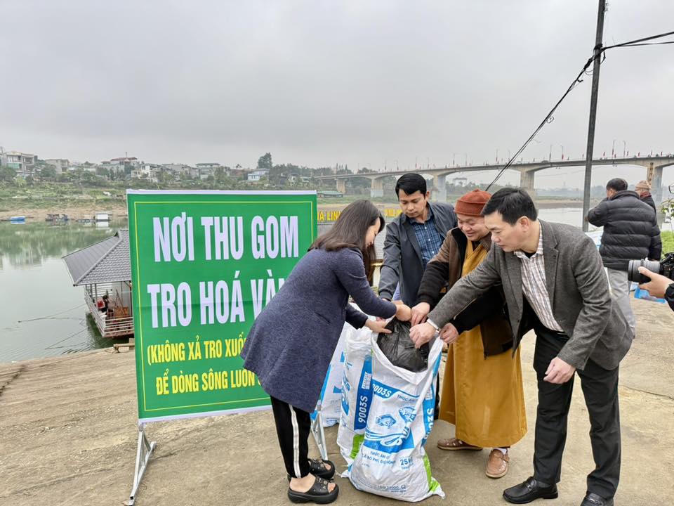 Ông Nguyễn Việt Khánh hướng dẫn người dân thu gom rác thải sau thả cá để bảo vệ môi trường.