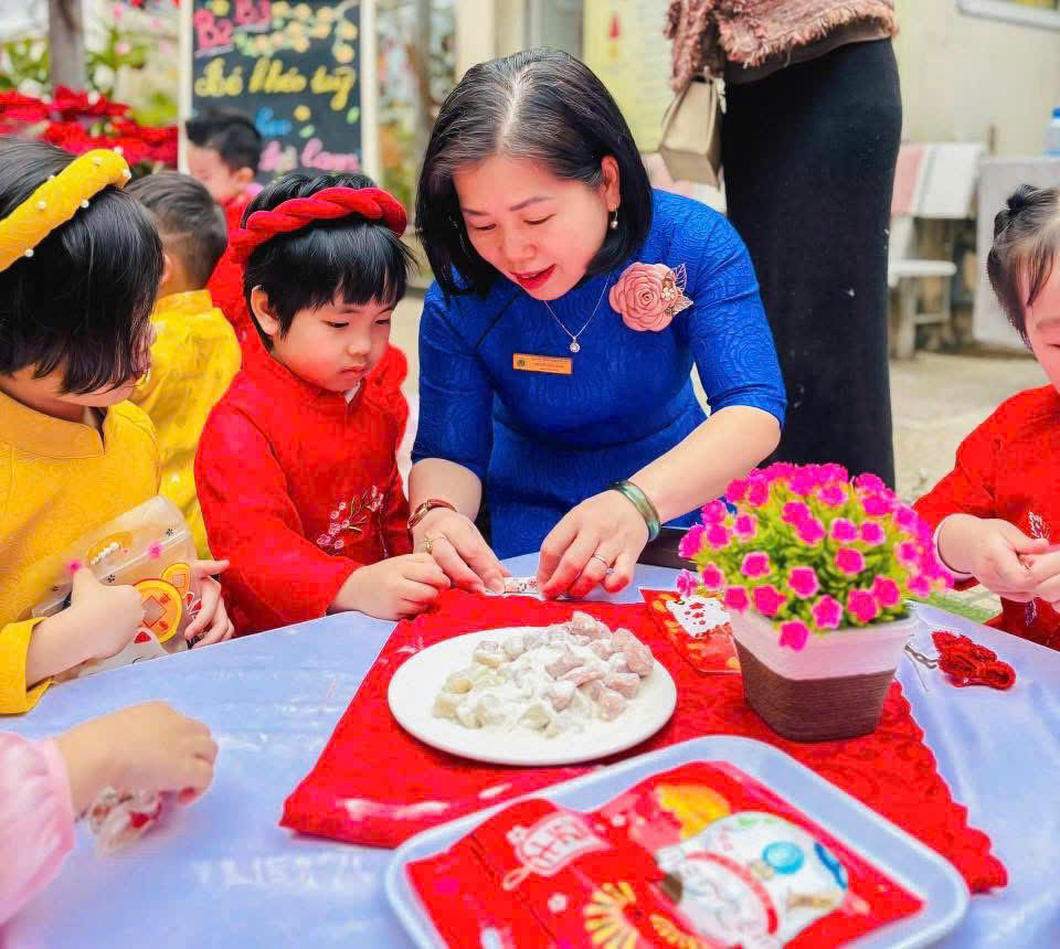 Các em nhỏ cùng cô gói kẹo lạc.&nbsp;