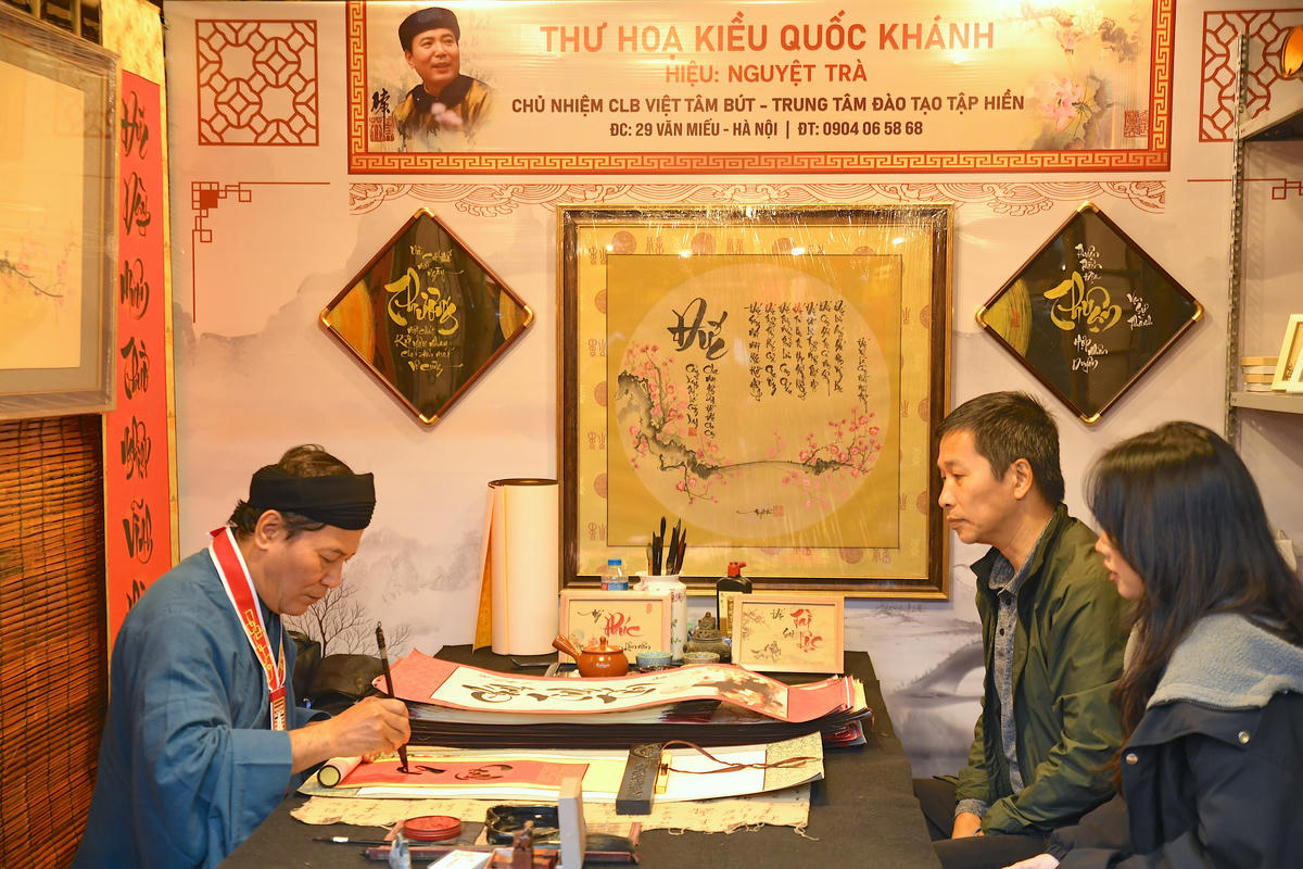 Ngay sau lễ khai mạc, nhiều người dân đã đến các gian thư pháp của các "ông đồ" để xin chữ. Ảnh: Phạm Sỹ.. 