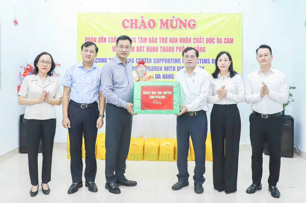 Bí thư Thành ủy Đà Nẵng Lê Ngọc Quang (bên trái) tặng quà chúc Tết Trung tâm Bảo trợ nạn nhân chất độc da cam và trẻ em nghèo bất hạnh TP Đà Nẵng. Ảnh: CV.