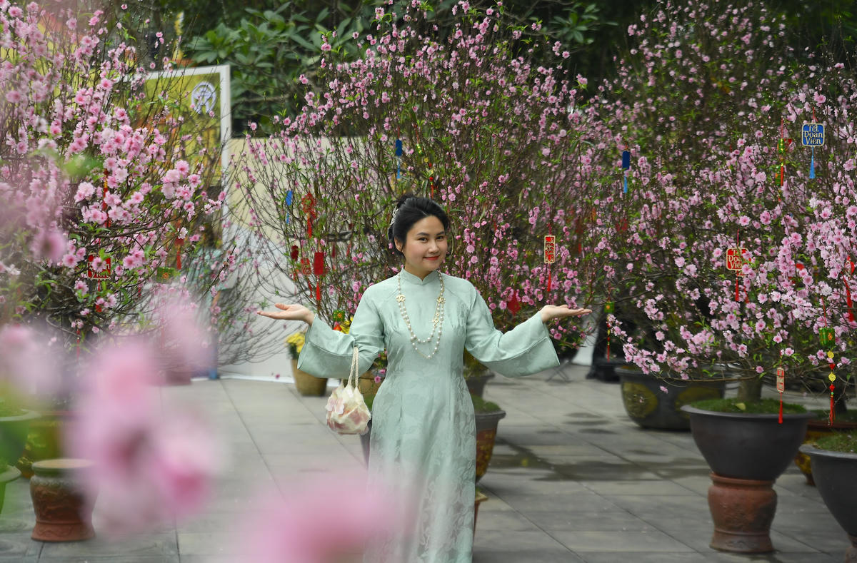 Trong tà áo dài duyên dáng các bạn trẻ đã tạo nên sự giao thoa giữa nét xưa và nhịp sống hôm nay, góp phần làm cho không gian hoa xuân thêm sinh động, trẻ trung. Ảnh: Phạm Sỹ.