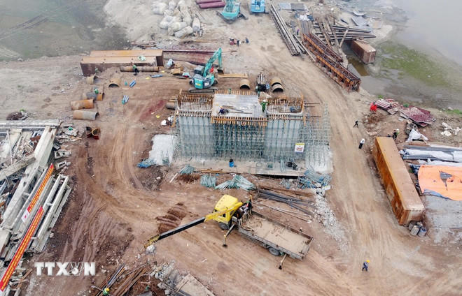 Sau 3 tháng khởi công, nhà thầu thi công cầu Phong Châu mới đã tập trung nhân lực, máy móc để đẩy nhanh tiến độ, phấn đấu hoàn thành trước kế hoạch đề ra. (Ảnh: Tạ Toàn/TTXVN).