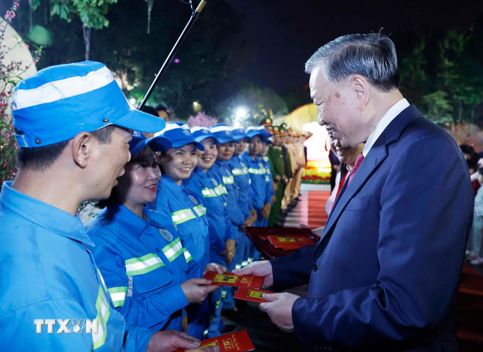 Tổng Bí thư Tô Lâm mừng tuổi cho công nhân môi trường đô thị tại khu vực vườn hoa Lý Thái Tổ. (Ảnh: Thống Nhất/TTXVN).