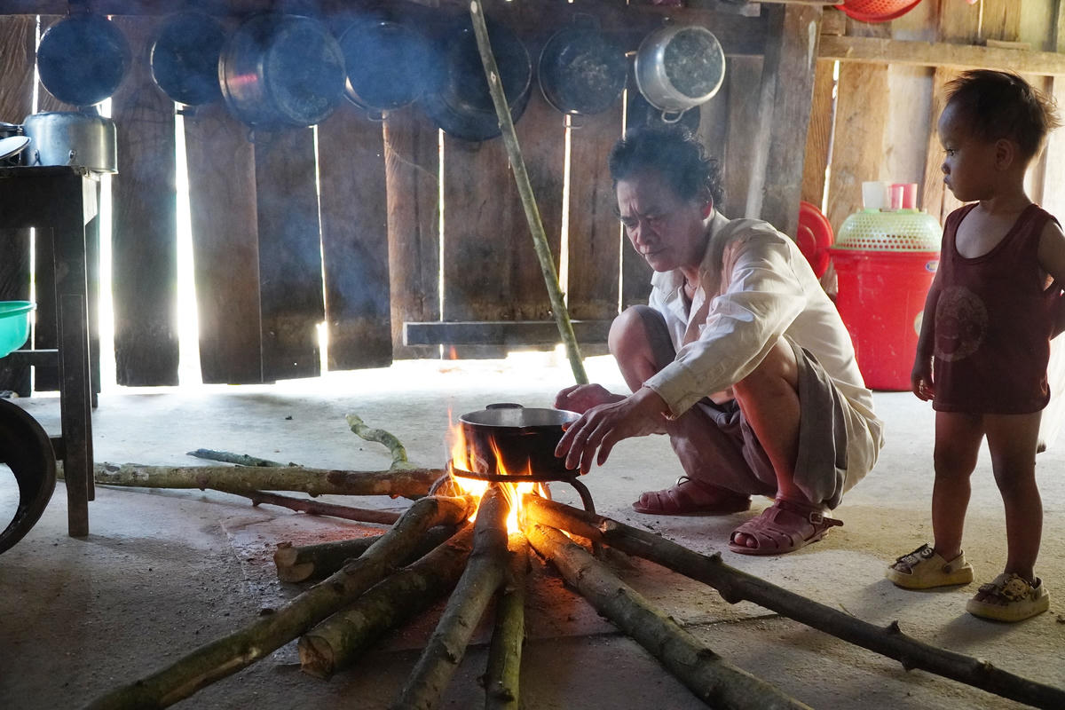 Ông Hồ Văn Định nấu cơm nếp để đón Tết. Ảnh: X.T