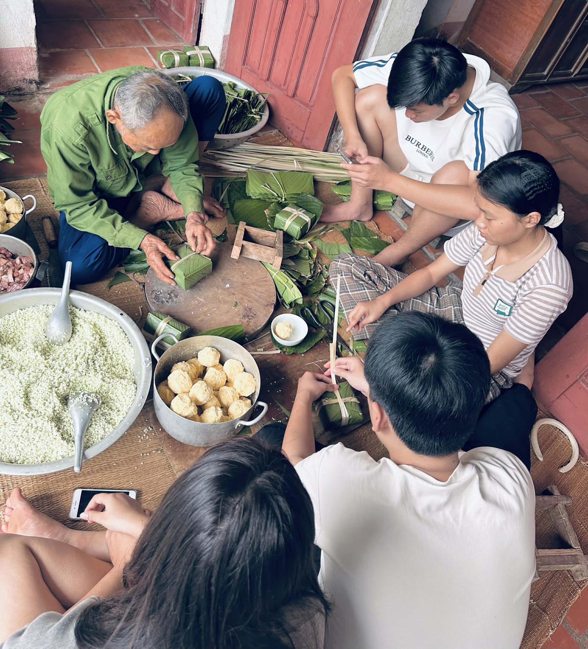 Gia đình em Lại Thị Lan Anh (trú xóm Nam, xã Biện Thượng) gói bánh chưng đón Tết. Ảnh: Đình Minh