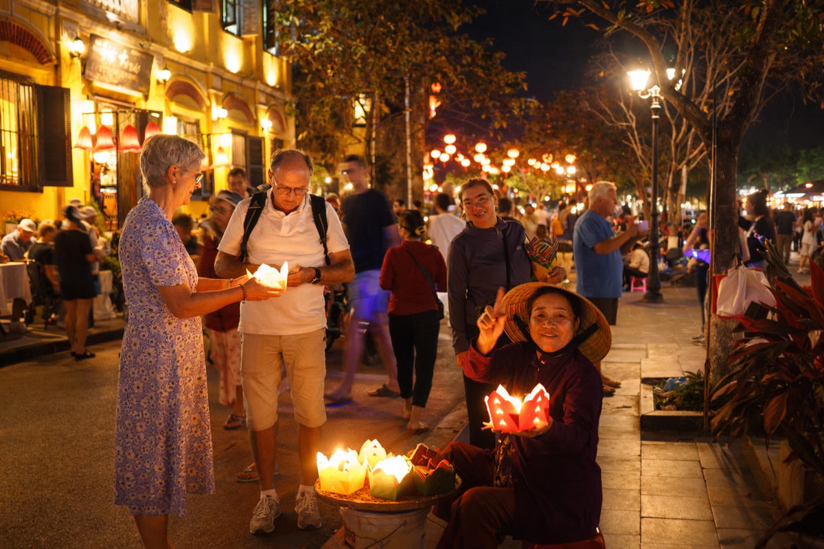 Du khách nước ngoài thích thả hoa đăng ở phố cổ Hội An. Ảnh: Nguyễn Tín.