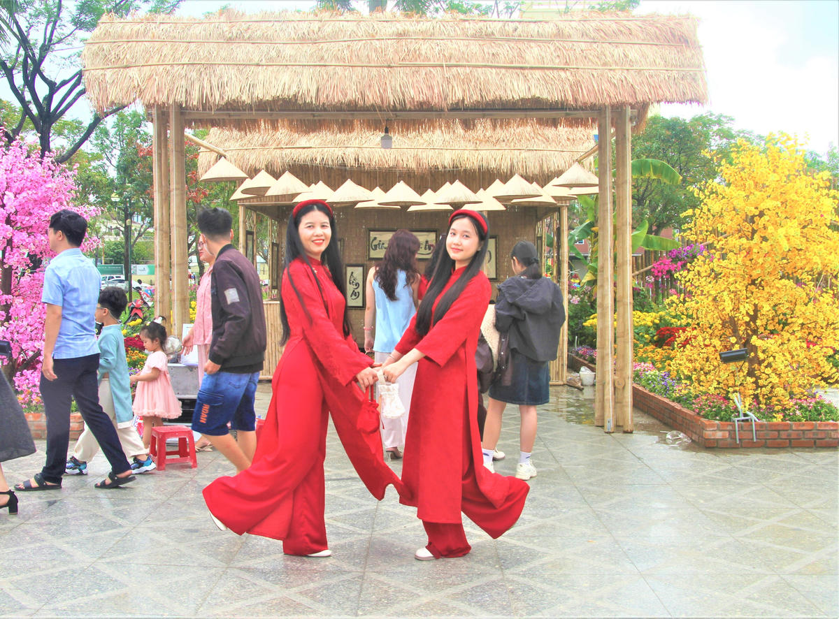 Mọi người thích thú chụp ảnh bên tiểu cảnh ngôi nhà tre đơn sơ gắn liền cuộc sống hằng của người dân. Ảnh: Chí Đại.