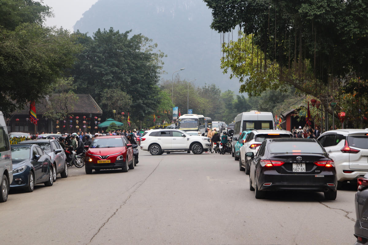 Trong tiết trời xuân dịu nhẹ, dòng người đổ về Ninh Bình từ sớm 19/2 (tức mồng 3 Tết). Tại các tuyến đường dẫn vào các khu du lịch, phương tiện nối đuôi nhau, từng đoàn khách áo quần rực rỡ sắc màu, tạo nên bức tranh xuân đầy sự tươi mới. Ảnh: Đình Minh