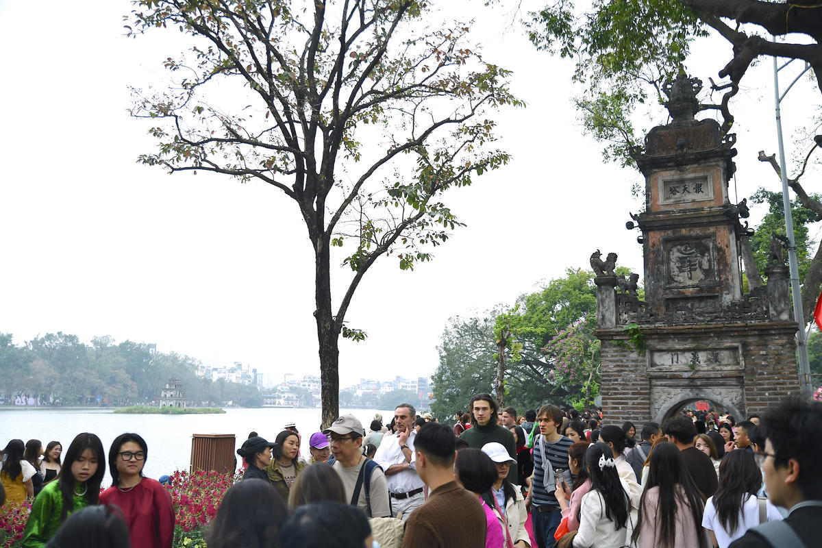 Dòng người thong thả dạo bước quanh Hồ Gươm, tận hưởng bầu không khí trong lành và khoảnh khắc bình yên giữa trung tâm thành phố. Ảnh: Phạm Sỹ.
