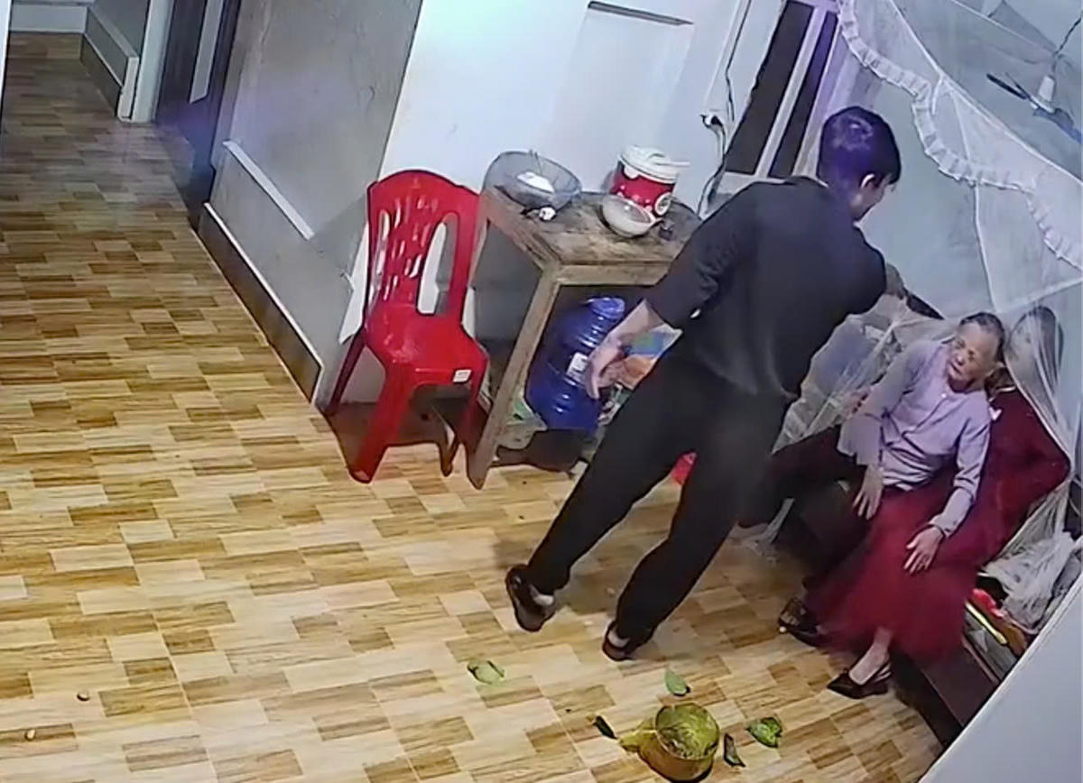 Hình ảnh người đàn ông cầm dao chỉ thẳng vào mẹ và chị gái de doạ. Ảnh: Cắt từ clip