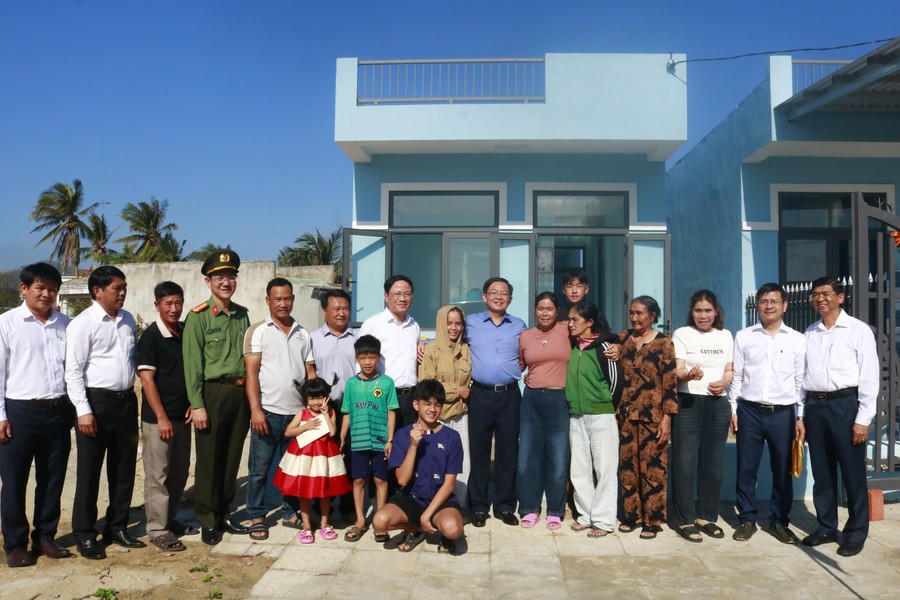 Phó Thủ tướng Chính phủ Hồ Quốc Dũng (áo xanh) chụp hình lưu niệm cùng các hộ gia đình được hỗ trợ xây dựng nhà ở trong “Chiến dịch Quang Trung” tại khu tái định cư xã Đề Gi. Ảnh: BĐ.