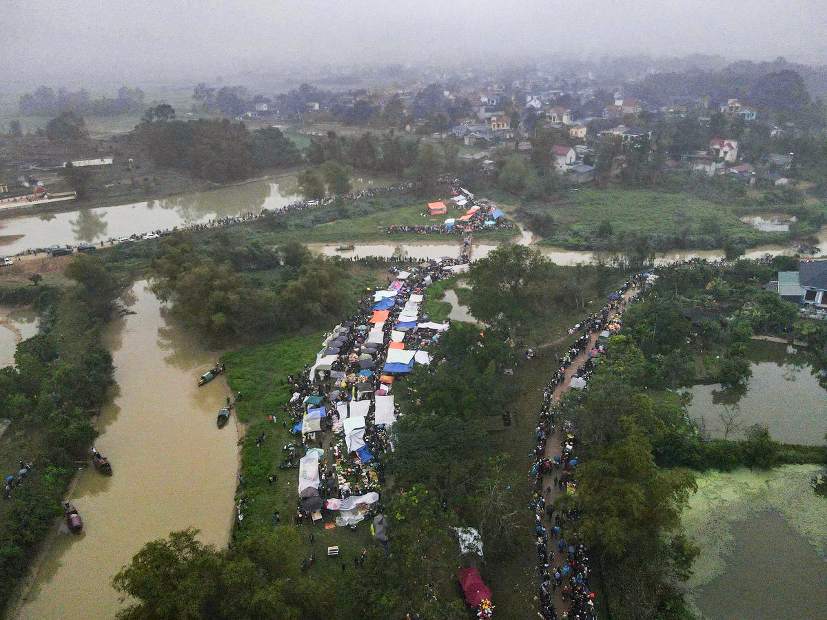 Từ sớm tinh mơ ngày 22/2, dòng người đã đổ về Chợ Chuộng, tạo nên khung cảnh đông đúc hiếm thấy tại bãi đất ven sông Hoàng. Theo UBND phường Đông Sơn, lễ hội năm nay thu hút hàng nghìn người tham gia. Ảnh: Đình Minh
