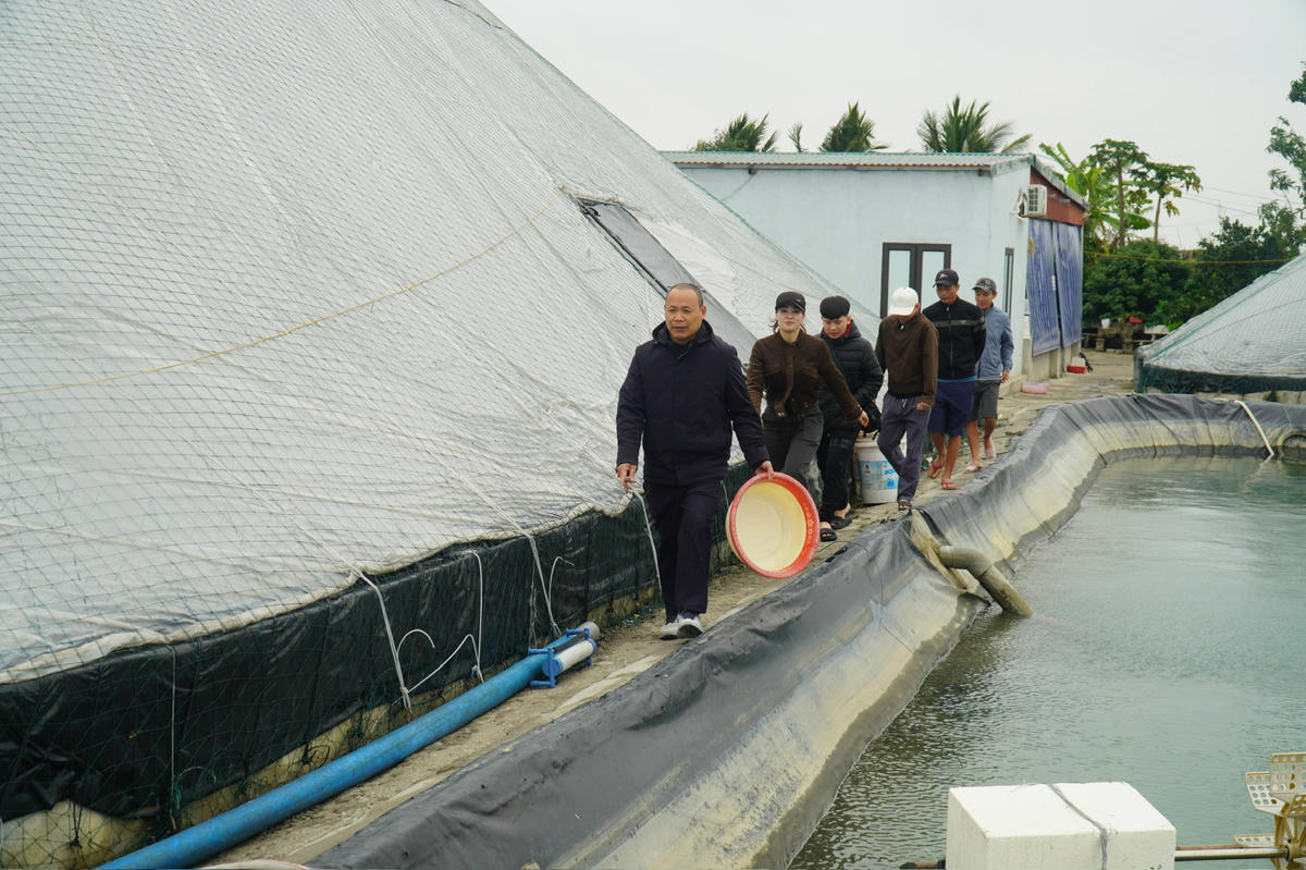 Ông Phương dẫn khách tới tham quan mô hình, chốt đơn tại ao nuôi. Ảnh: Đình Minh