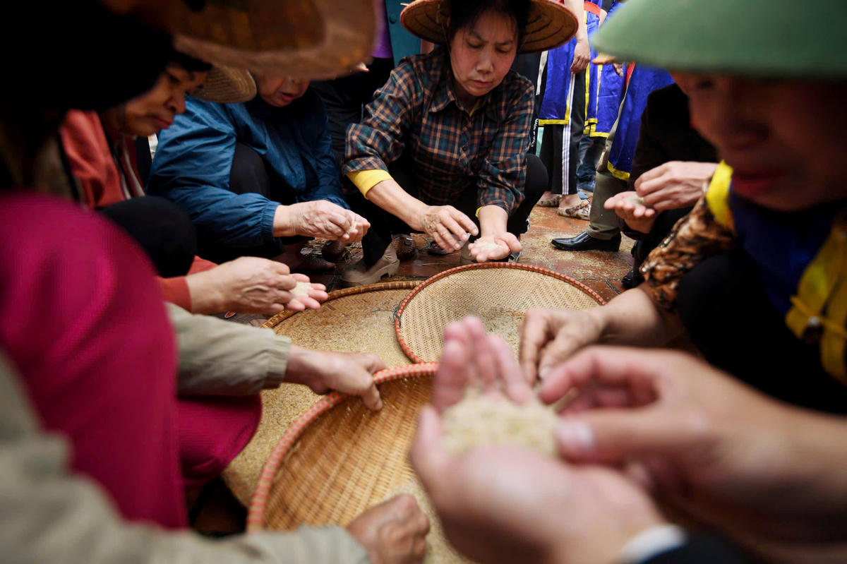 Các bà, các chị đảm nhiệm phần sàng sảy, vo gạo sau khi thóc được giã, chuẩn bị cho công đoạn thổi cơm. Ảnh: Phạm Sỹ.