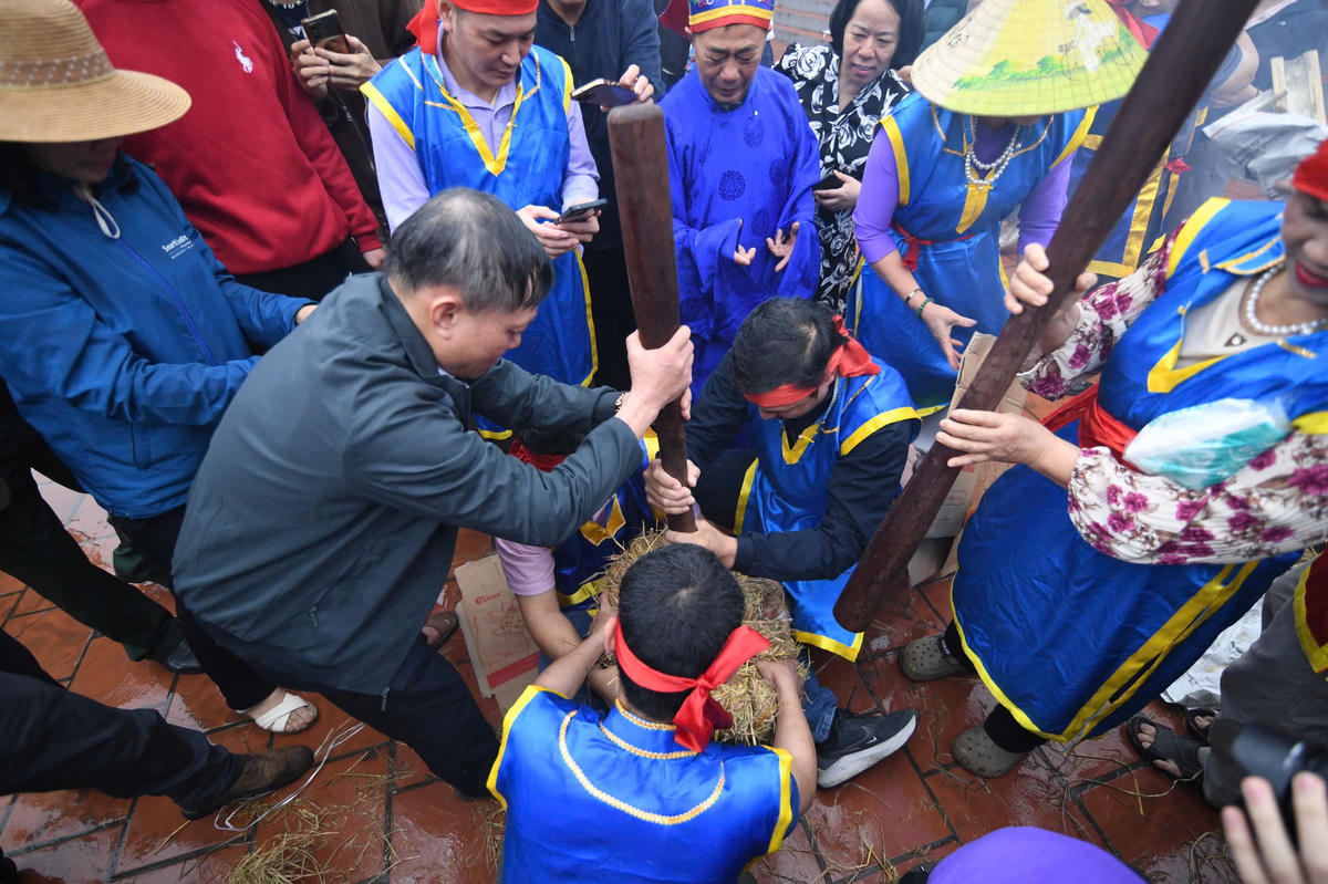 Các nam thanh niên tập trung giã thóc trong cối đá, giữa tiếng hò reo vang dội. Ảnh: Phạm Sỹ.&nbsp;