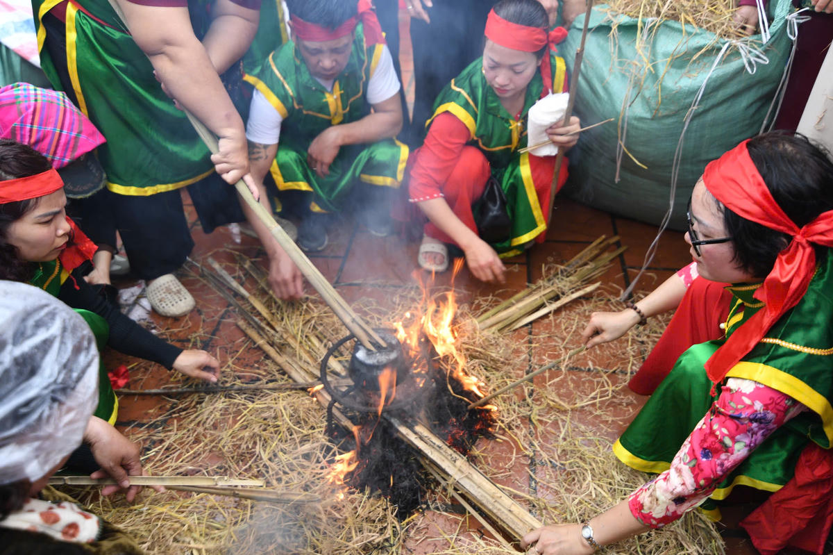 Sau khi nồi cơm sôi, nước cạn, sẽ được các đội thị khéo léo ủ trong lớp tro nóng để cơm chín đều. Ảnh: Phạm Sỹ.