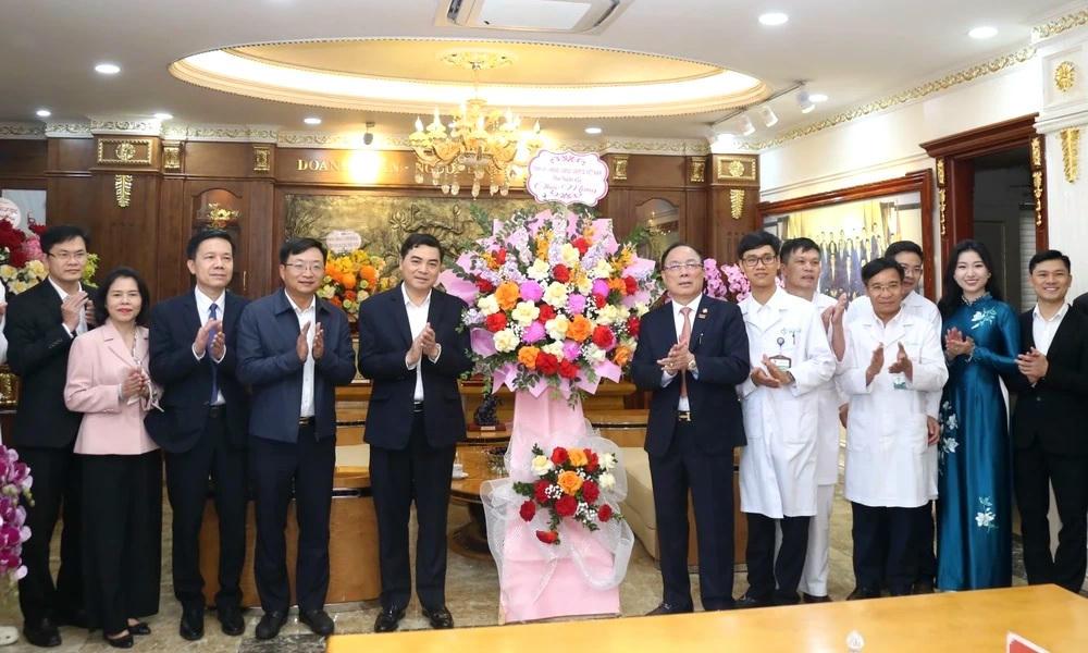 Chủ tịch UBND tỉnh Nguyễn Hoài Anh tặng hoa chúc mừng Tổng Công ty CP Hợp Lực và cán bộ, y bác sĩ trong hệ thống y tế của đơn vị. Ảnh: Phong Sắc