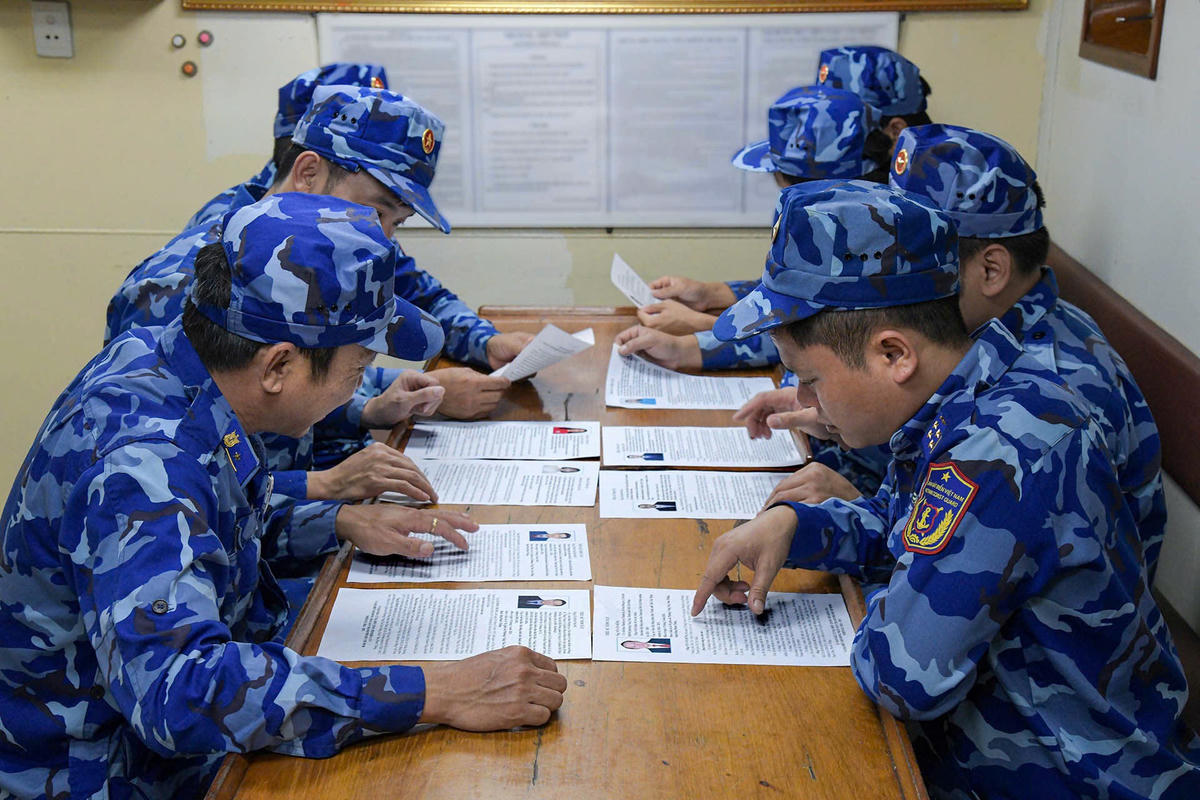 Cử tri nghiên cứu tiểu sử, chương trình hành động của người ứng cử. Ảnh: Đức Định.
