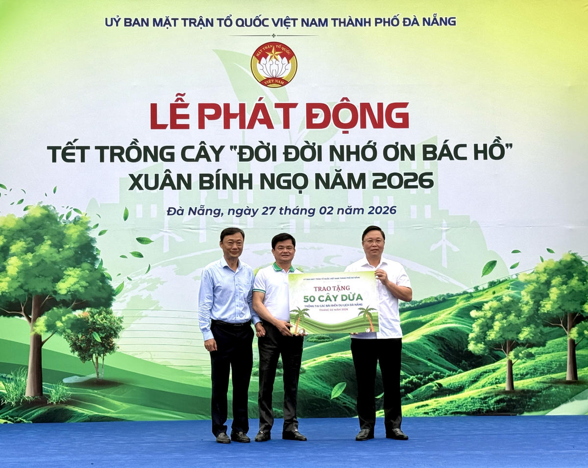 Ông Nguyễn Đức Vũ, Trưởng Ban quản lý bán đảo Sơn Trà và các bãi biển du lịch Đà Nẵng, cùng ông Nguyễn Hòa, Chủ tịch UBND phường Ngũ Hành Sơn nhận 50 cây dừa do Mặt trận thành phố tặng. Ảnh: Nguyễn Tú.