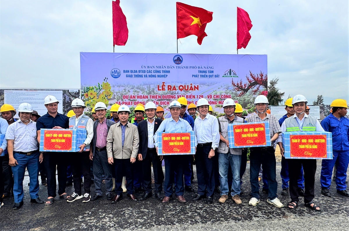 Phó Bí thư thường trực TP Đà Nẵng Nguyễn Đình Vĩnh (bên trái, áo vêt xanh) tặng quà cho đơn vị thi công. Ảnh: Nguyễn Tín.