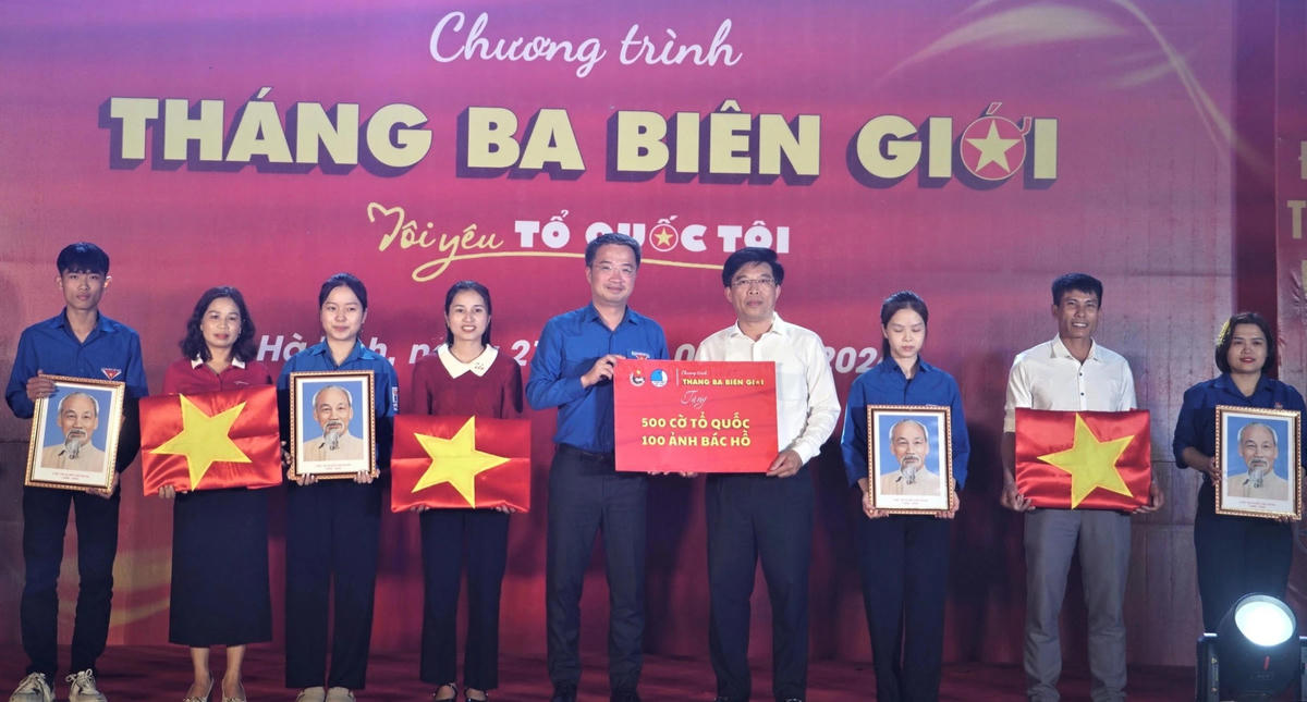 Bí thư Trung ương Đoàn, Chủ tịch Trung ương Hội Liên hiệp Thanh niên Việt Nam Nguyễn Tường Lâm trao tặng ảnh Bác Hồ và 100 lá cờ Tổ quốc cho người dân xã Sơn Kim 1. Ảnh: ĐH.