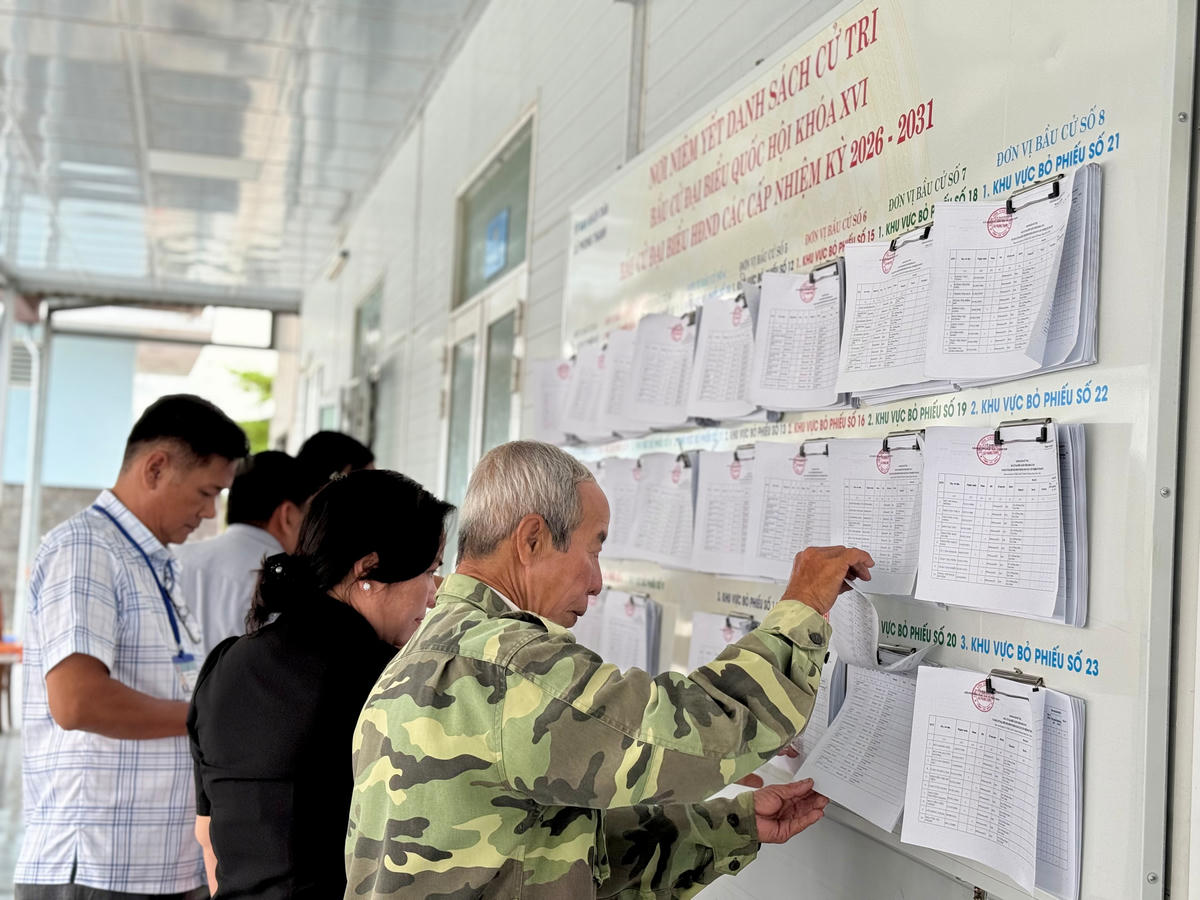 Bà Phạm Thanh Thuý, Chủ tịch Uỷ ban MTTQ Việt Nam xã Phong Thạnh (áo đen) giám sát việc lập, niêm yết danh sách cử tri của UBND xã. Ảnh: Nguyên Du