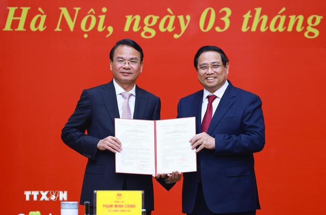 Thủ tướng Phạm Minh Chính trao Quyết định của Thủ tướng Chính phủ về việc tiếp nhận, bổ nhiệm ông Đặng Xuân Phong giữ chức Phó Chủ nhiệm Thường trực Văn phòng Chính phủ. (Ảnh: Dương Giang/TTXVN).