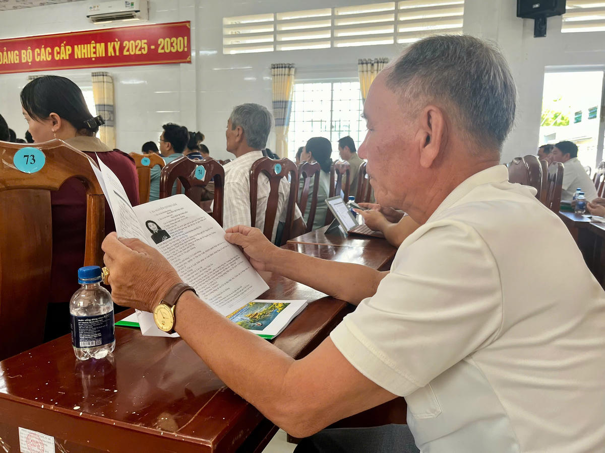 Cử tri Nguyễn Văn Chấn xem thông tin về tiểu sử của bà Nguyễn Quỳnh Liên. Ảnh: Thanh Tiến.