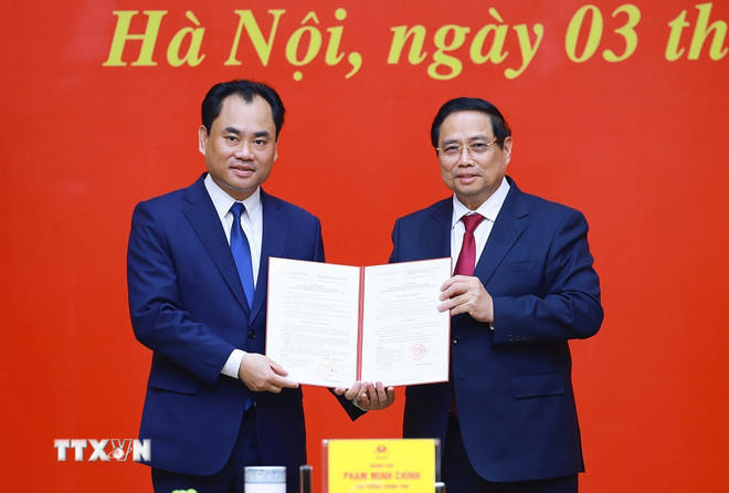 Thủ tướng Phạm Minh Chính trao Quyết định của Thủ tướng Chính phủ về việc tiếp nhận, bổ nhiệm ông Trịnh Việt Hùng giữ chức Thứ trưởng Thường trực Bộ Nông nghiệp và Môi trường. (Ảnh: Dương Giang/TTXVN).