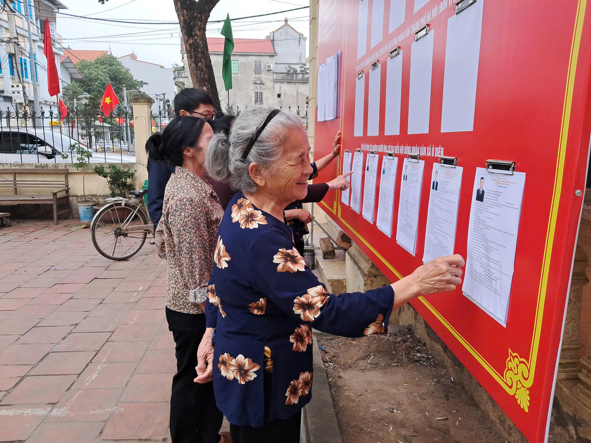 Bà con nhân dân theo dõi danh sách ứng cử viên ĐBQH và HĐND các cấp được niêm yết tại Nhà văn hóa Cụm 1 Liên Hà, xã Ô Diên, TP Hà Nội. Ảnh: N. P.