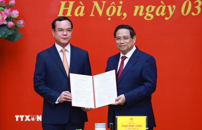 Thủ tướng Phạm Minh Chính trao Quyết định của Thủ tướng Chính phủ về việc tiếp nhận, bổ nhiệm ông Nguyễn Đình Khang, Phó Chủ tịch Ủy ban Trung ương Mặt trận Tổ quốc Việt Nam, Chủ tịch Tổng Liên đoàn Lao động Việt Nam giữ chức Thứ trưởng Thường trực Bộ Dân tộc và Tôn giáo. (Ảnh: Dương Giang/TTXVN).