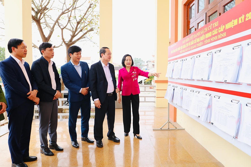 Bà Nguyễn Thị Thanh và ông Mai Văn Tuất kiểm tra danh sách niêm yết các ứng cử viên tại xã Kim Sơn. Ảnh: Đức Lam