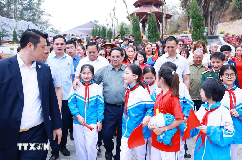 Thủ tướng Phạm Minh Chính với học sinh tỉnh Điện Biên dự Lễ khánh thành công trình bảo tồn, tôn tạo di tích Khu trung tâm đề kháng Him Lam (giai đoạn II). (Ảnh: Dương Giang/TTXVN).