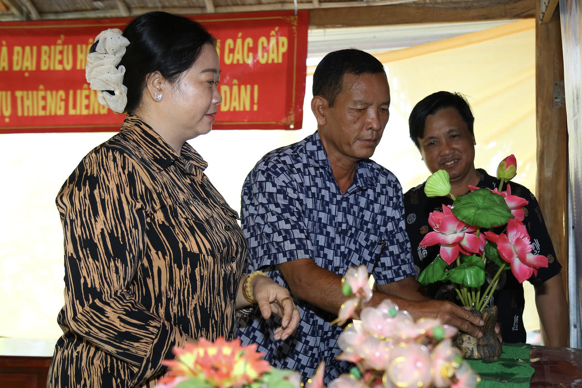 Ông Danh Tịnh (ở giữa) tham gia trang trí điểm bỏ phiếu đặt tại nhà mình. Ảnh: Thanh Tiến