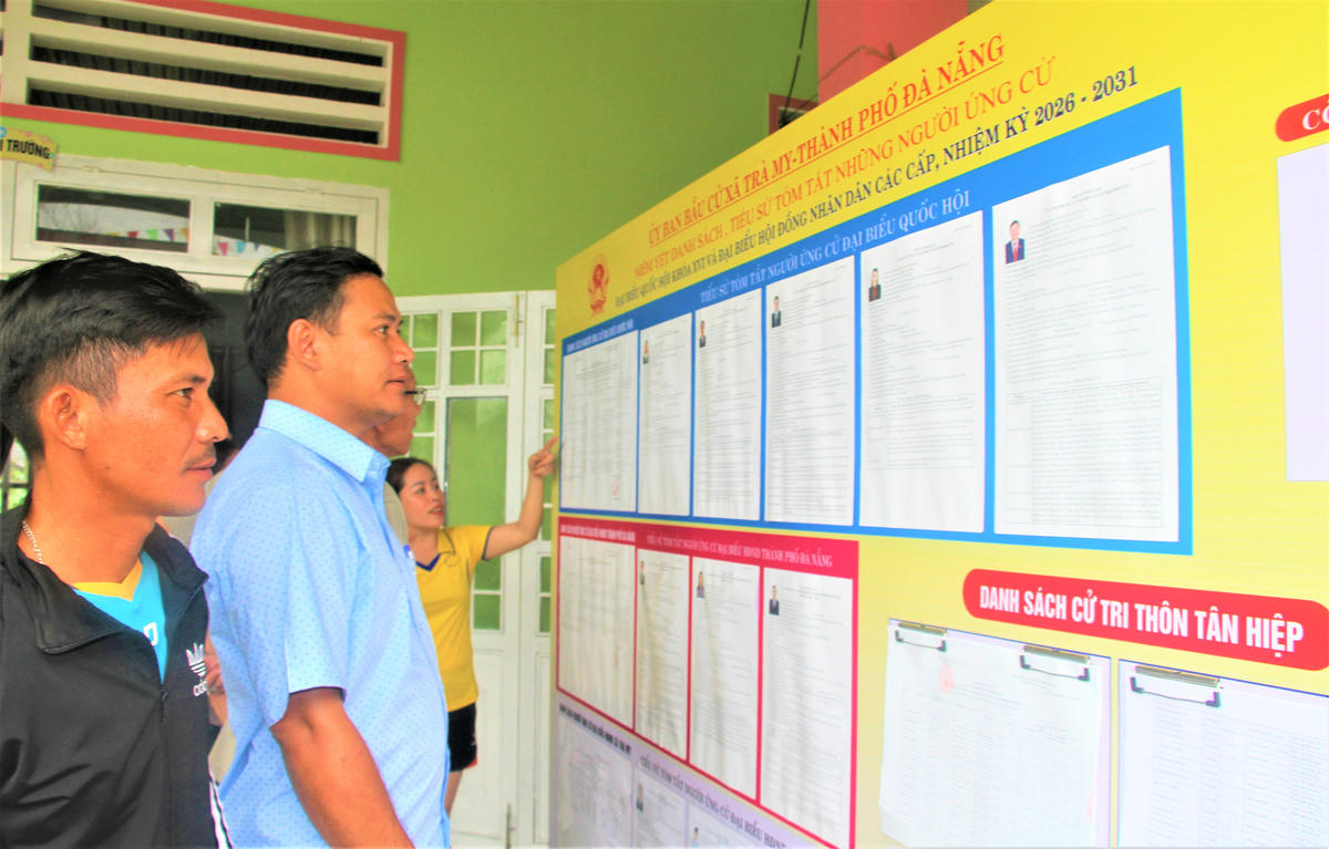 Cử tri thôn Tân Hiệp, xã Trà My đi xem niêm yết danh sách ứng cử viên ĐBQH khóa XVI. Ảnh: Chí Đại.