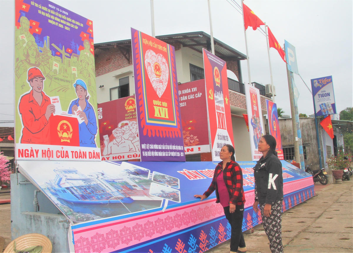Người dân xã đảo Tam Hải xem áp phích tuyên truyền bầu cử. Ảnh: Tấn Thành.