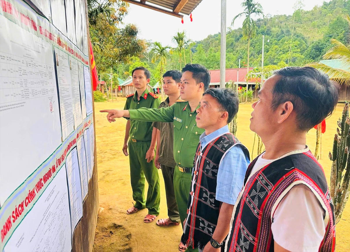 Lực lượng Công an xã A Vương hướng dẫn cử tri xem ứng cử viên ĐBQH khóa XVI. Ảnh: CV.